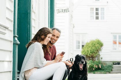 ungt par med hund som sitter i gamle Skudeneshavn på karmøy