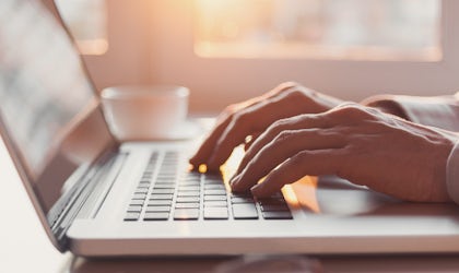 hender som skriver på tastatur på bærbar pc