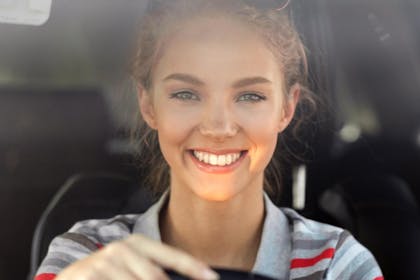ung kvinner kjører bil sett forfra