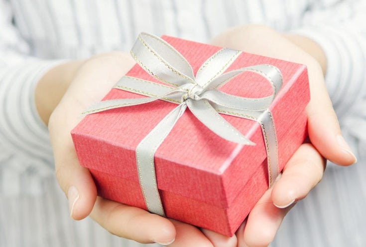hender som holder fint innpakket gave