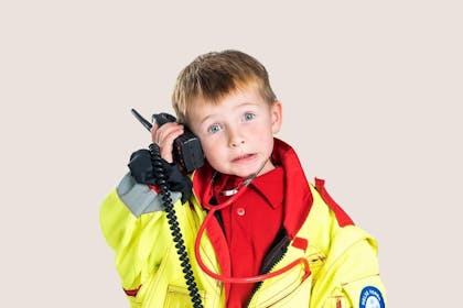 ung gutt kledd i ambulansedrakt og med vakttelefon