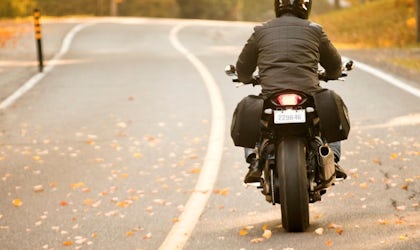 motorsykkel kjører på vei med høstrær langs veien