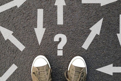sko står på vei med piler på asfalten som peker alle veier.