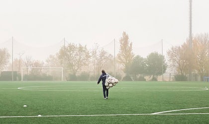Person som bærer ballnett på en tom fotballbane