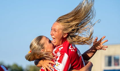 To glade spiller fra Avaldsnes Toppforball damelag, som hopper og klemmer hverandre