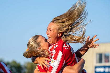 To glade spiller fra Avaldsnes Toppforball damelag, som hopper og klemmer hverandre